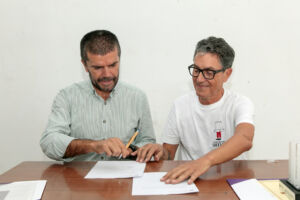 El rector y el diseñador firman el acta de donación. 