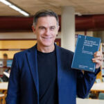 Javier Giner, uno de los coautores del libro, posa con un ejemplar durante la presentación celebrada en la Facultad de Economía, Empresa y Turismo.