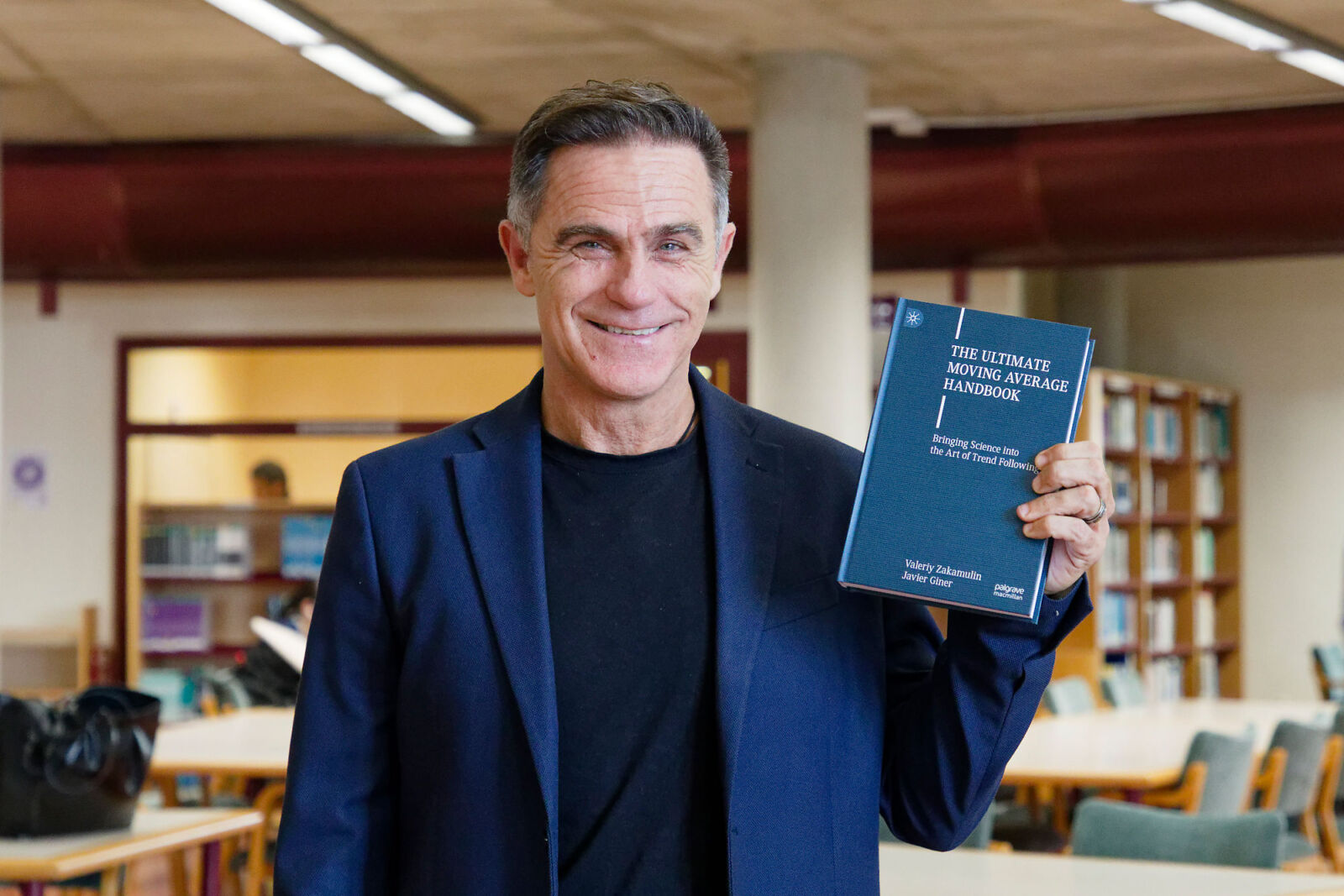 Javier Giner, uno de los coautores del libro, posa con un ejemplar durante la presentación celebrada en la Facultad de Economía, Empresa y Turismo.