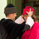 El rector impone el birrete a una de las doctoras investidas en la ceremonia celebrada en el Paraninfo.